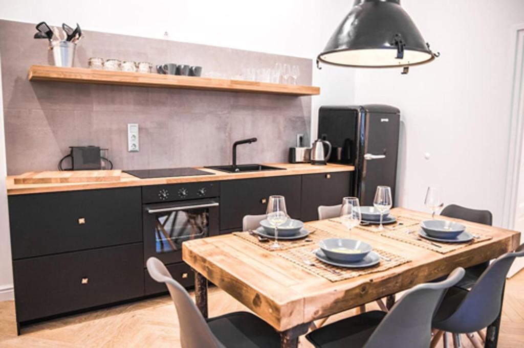 a kitchen with a wooden table with chairs and a sink at IRANYI Home - flat in the heart of downtown in Budapest