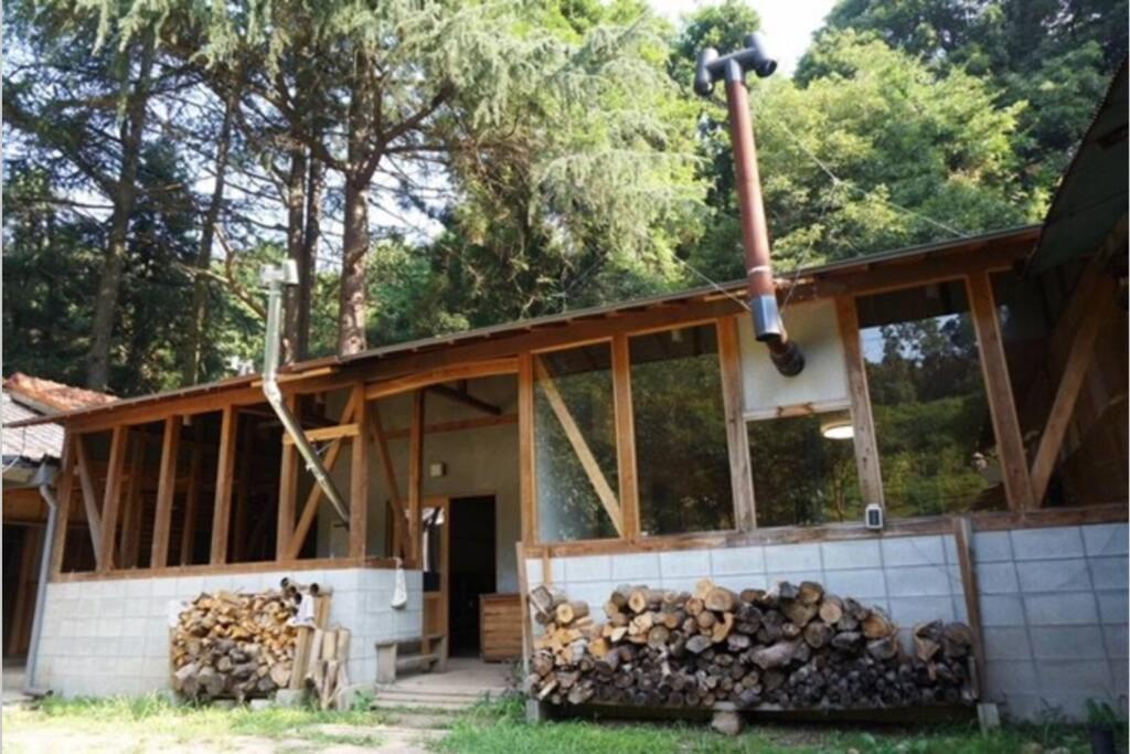 a house being constructed with a pile of fire wood at toyoukenomori in Mitsugarasuchō