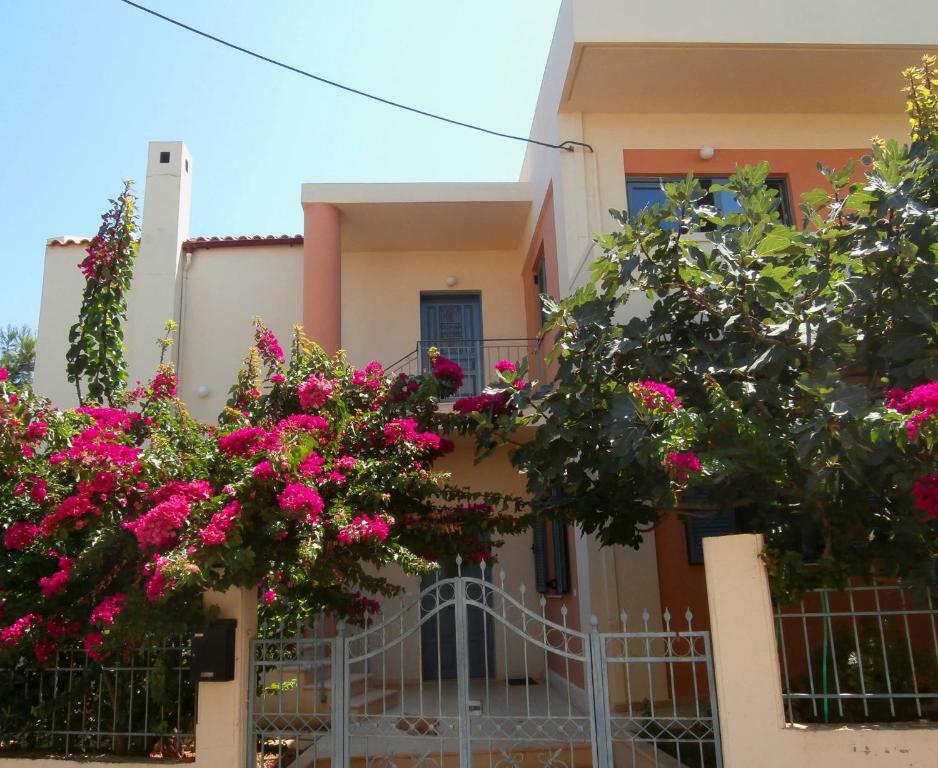 una casa con flores rosas delante de ella en Glaros Home en Kato Daratso