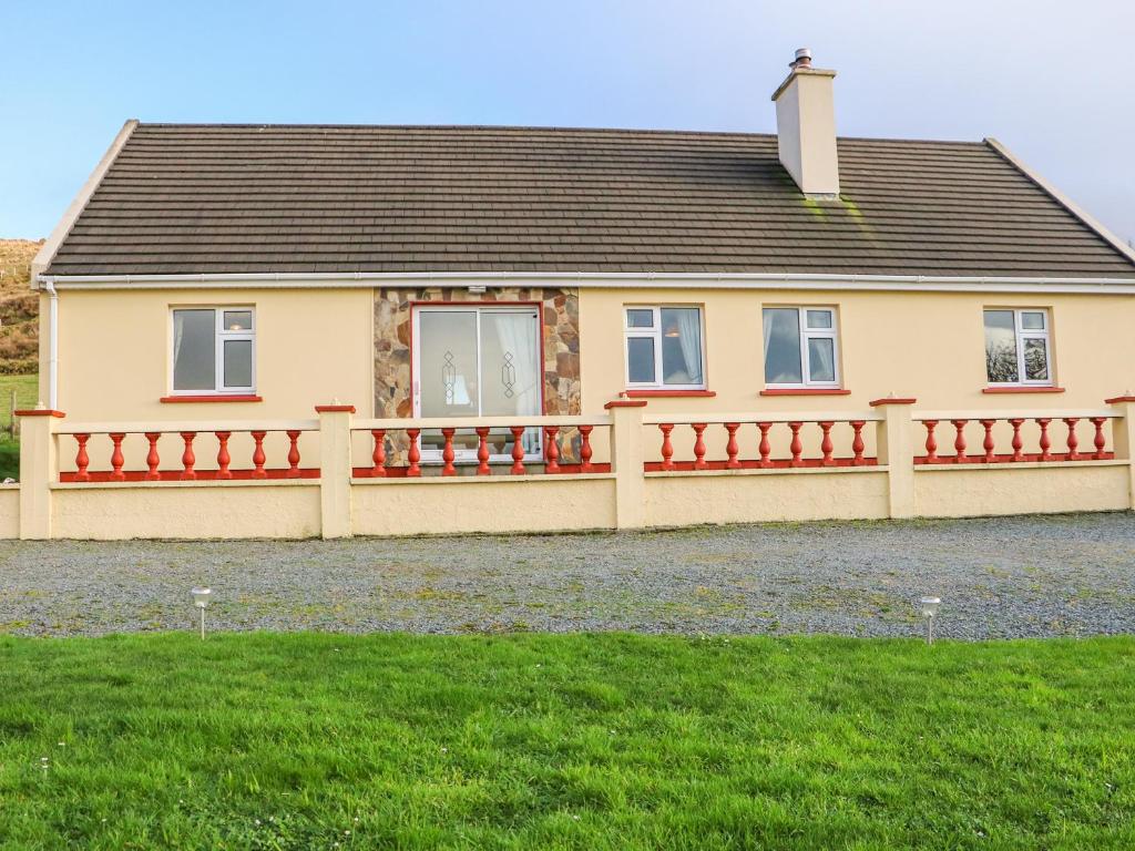 une maison avec une clôture en bois devant elle dans l'établissement Upper Haven, à Eyeries