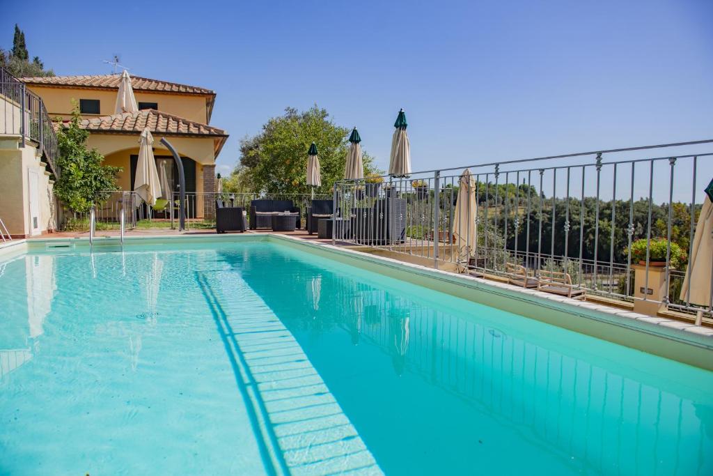 a swimming pool with blue water in front of a house at Villa Denise in Campiglia Marittima