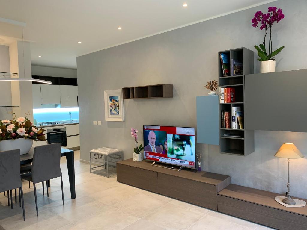 sala de estar con TV de pantalla plana en la pared en A Casa di Chiara 2 en Stresa