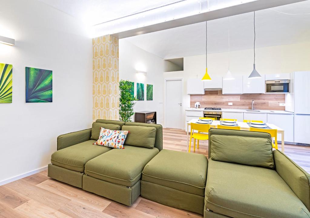 un soggiorno con 2 divani verdi e una cucina di CITy TURIN HUB a Torino