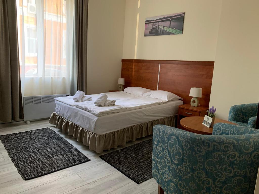 Habitación de hotel con cama y silla en Guest Rooms Donovi, en Varna