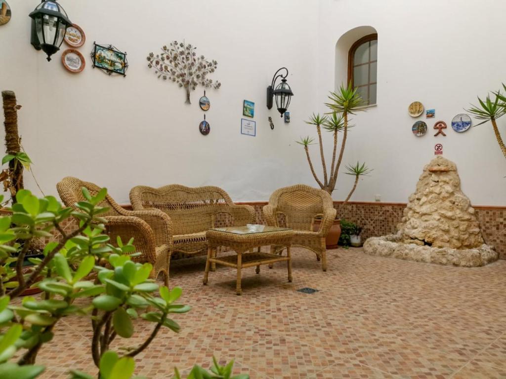 ein Wohnzimmer mit Korbstühlen und einem Tisch in der Unterkunft Hotel Plaza Escribano in Moguer