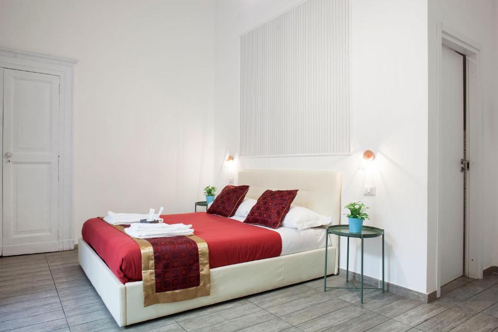 una camera da letto con un letto con lenzuola rosse e un tavolo di B&B Martucci Avenue a Napoli