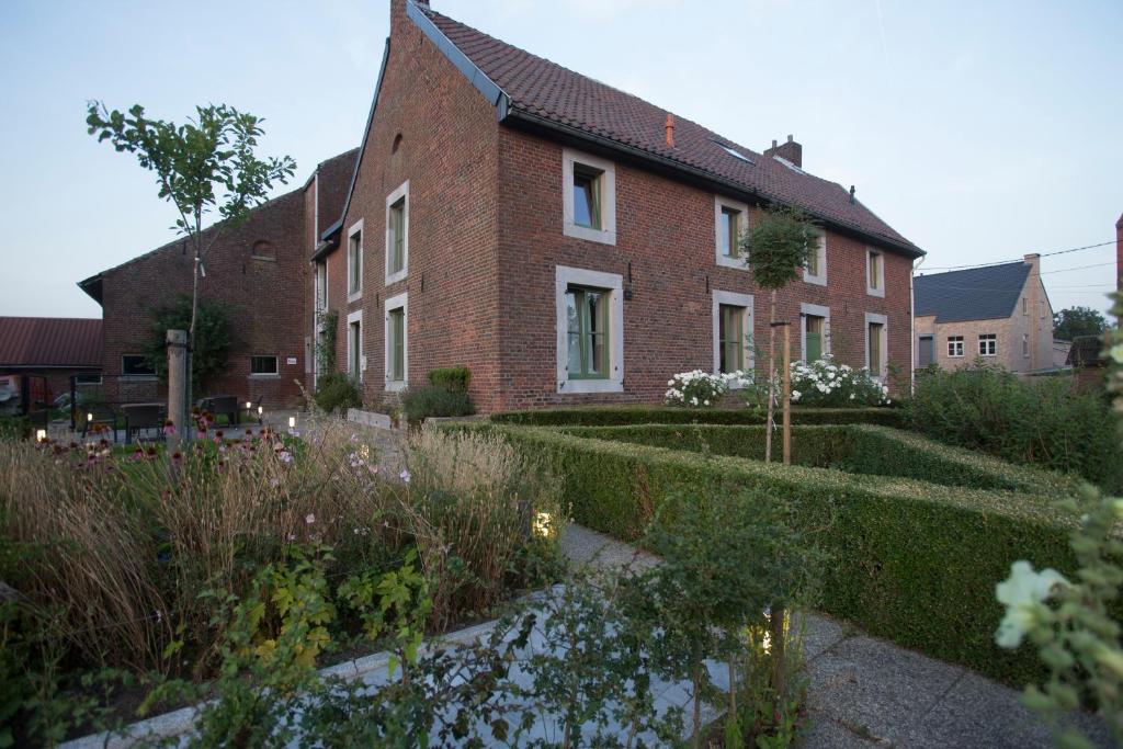 una casa de ladrillo con un jardín delante de ella en B&B Haspenhoeve, en Tongeren