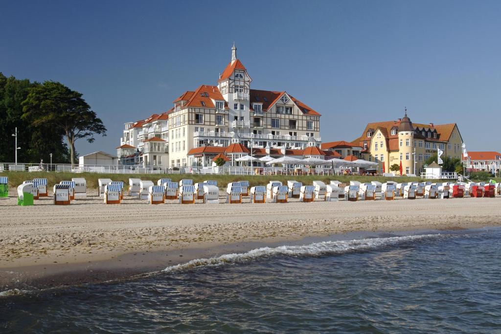 Una playa con sillas y un hotel al fondo. en Haus Meeresblick, en Kühlungsborn