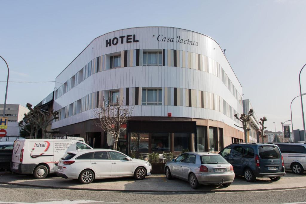 un hôtel avec des voitures garées devant lui dans l'établissement Hotel Casa Jacinto, à Burlada