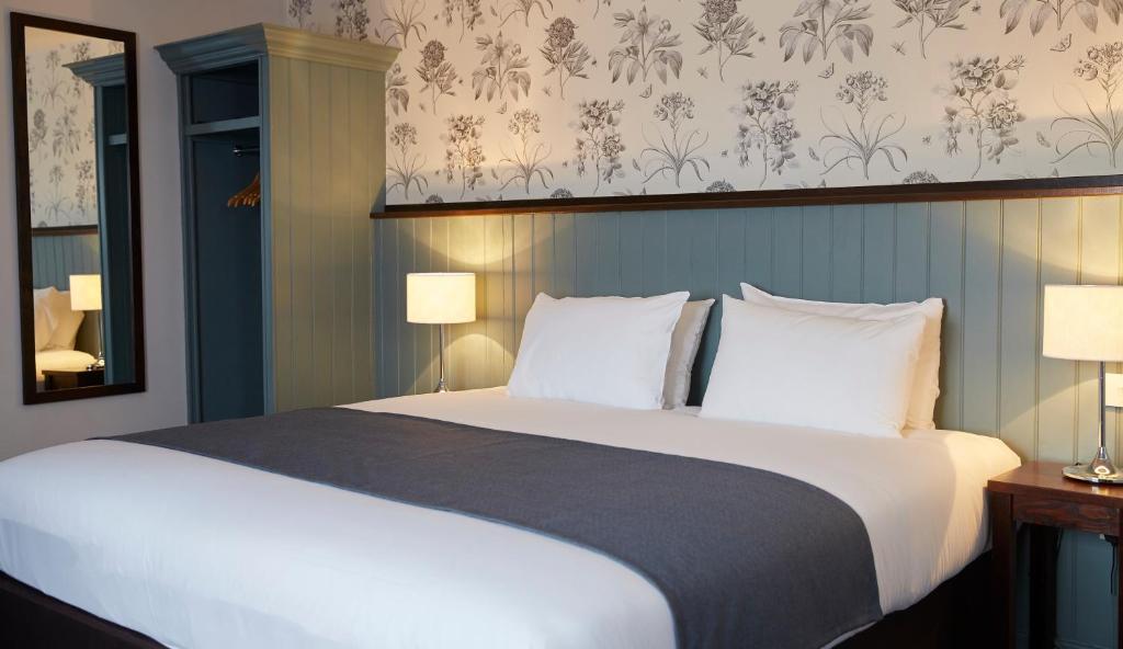 1 dormitorio con 1 cama grande con almohadas blancas en Ravensworth Arms by Chef & Brewer Collection en Gateshead