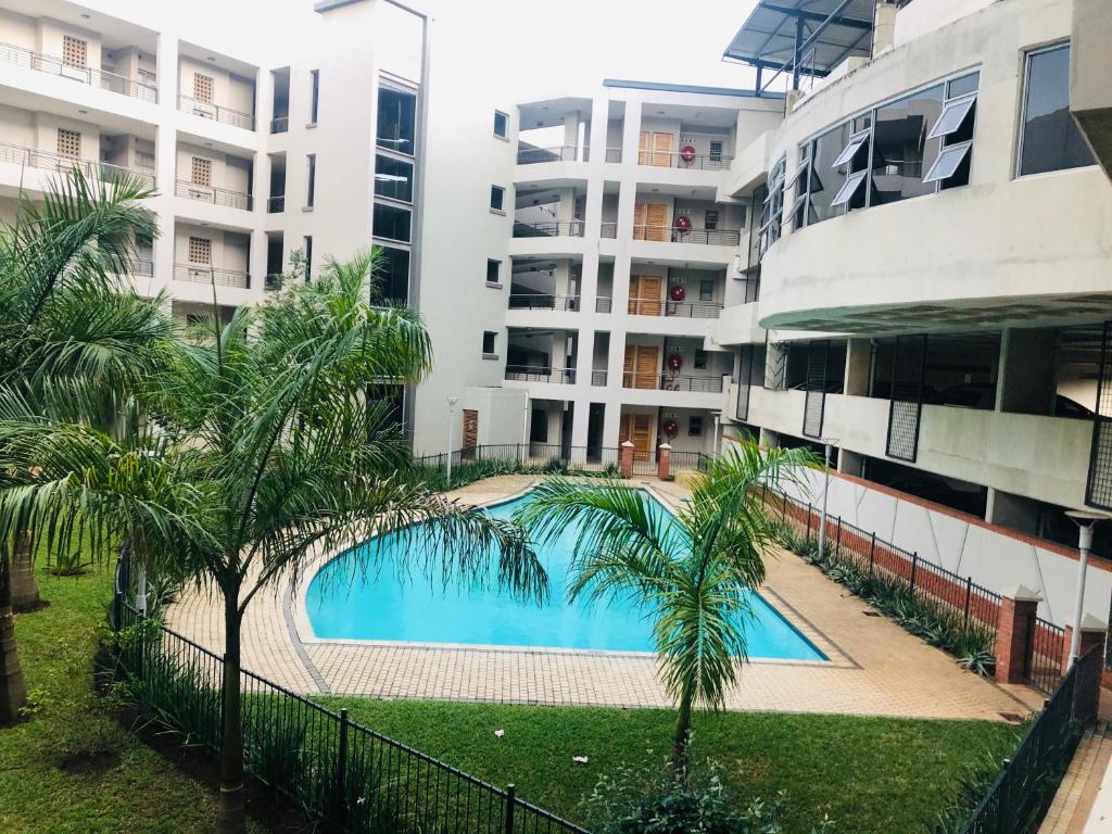 a swimming pool in front of a building at Umhlanga Ridge self-catering apartment in Durban
