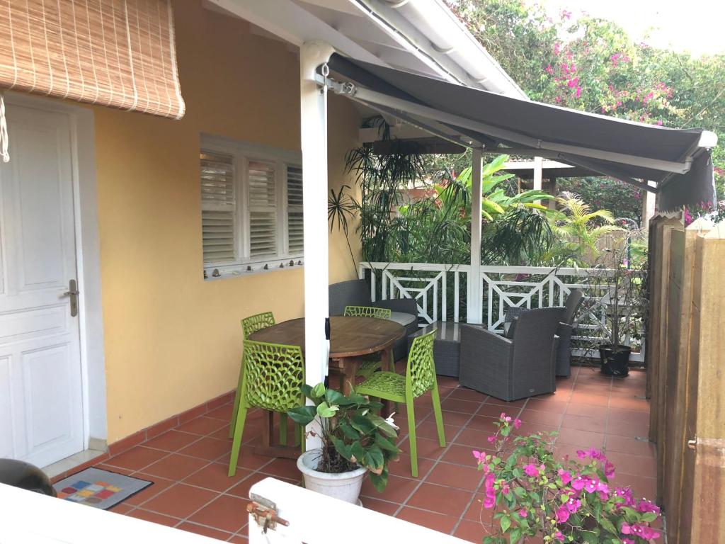 a patio with a table and chairs under awning at Eden Kay in Les Trois-Îlets