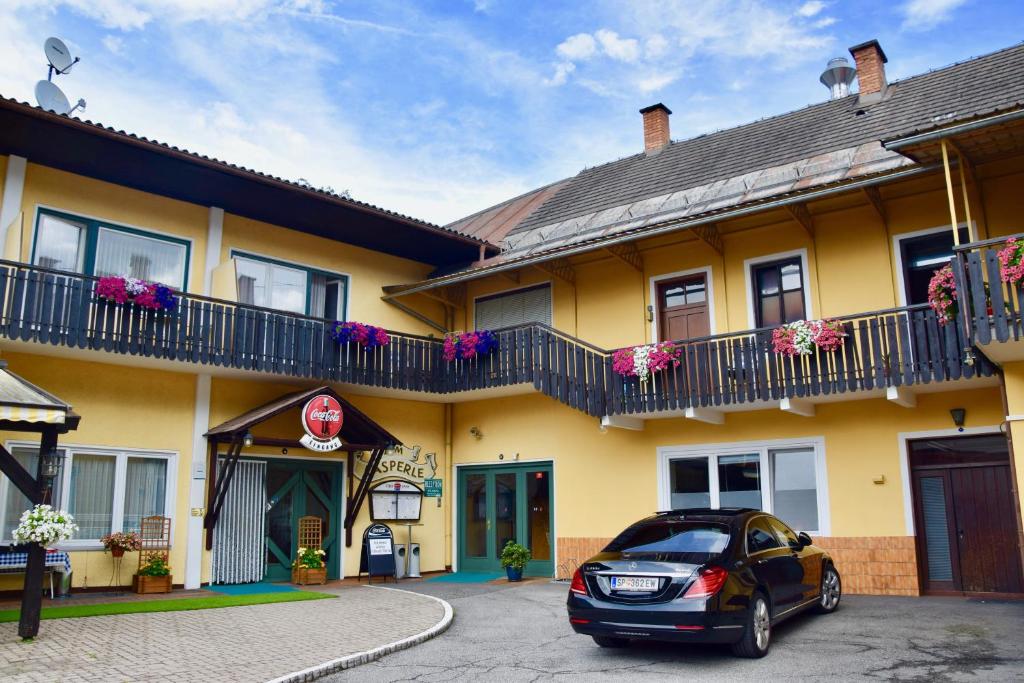 a car parked in front of a yellow building at Gasthof Kasperle in Spittal an der Drau