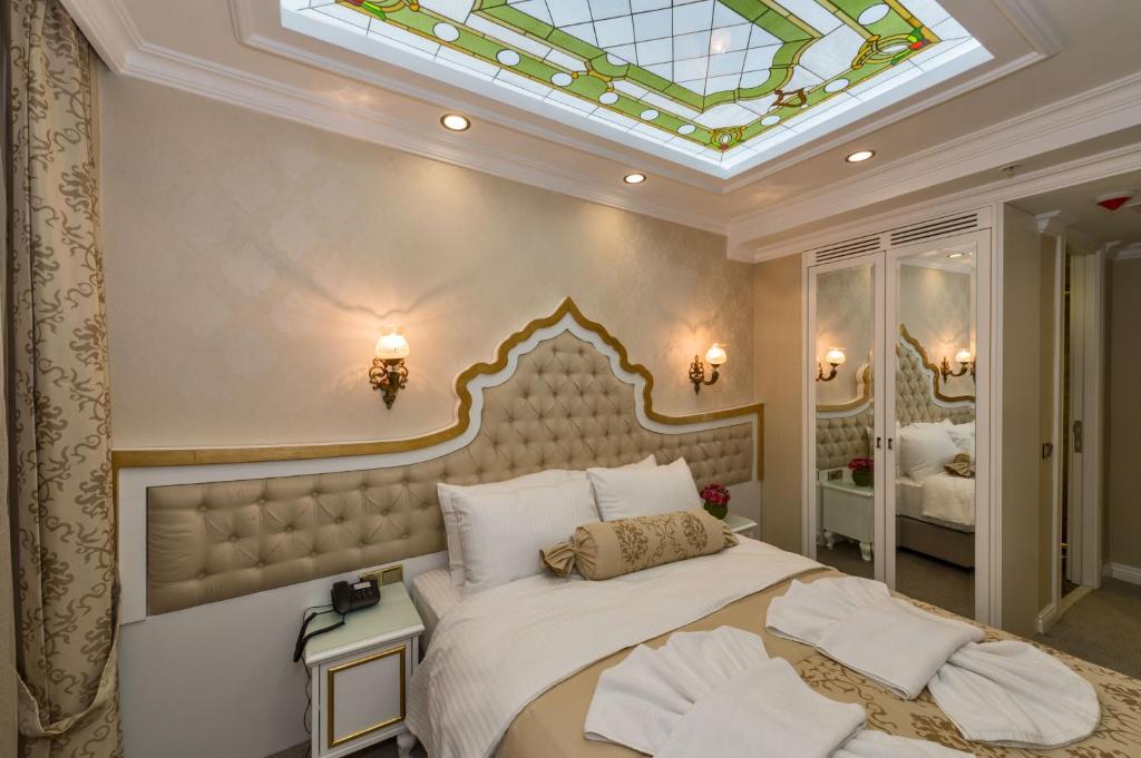 a bedroom with a large bed with a skylight at Alpek Hotel in Istanbul