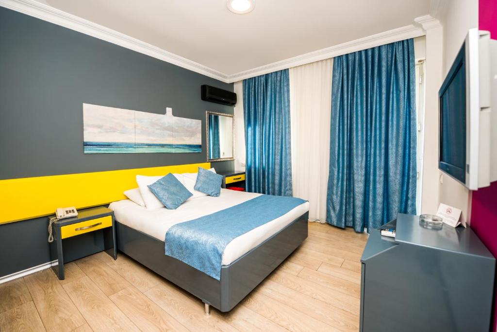 a hotel room with a bed and a television at Mera Park Hotel in Antalya