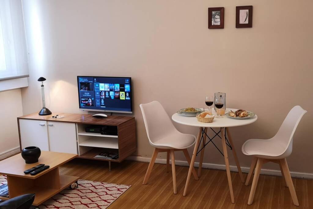sala de estar con mesa con sillas y TV en 2 ambientes en Almagro en Av Corrientes para 2 personas en Buenos Aires