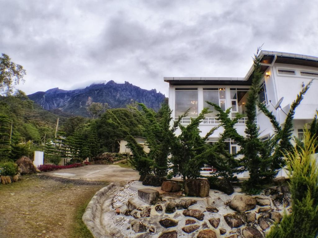 a house with a mountain in the background at Sling N Stone Vacation Homes, Mt Kinabalu in Kundasang