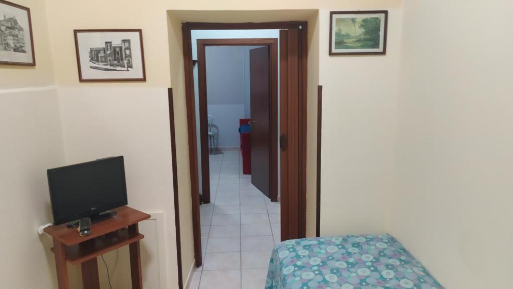 Habitación con TV y puerta a un pasillo en Casa fiordaliso, en Bonea