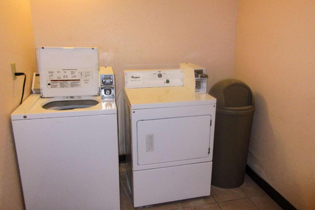 a small kitchen with a washer and dryer next to a trash can at Quality Inn in Sawyer