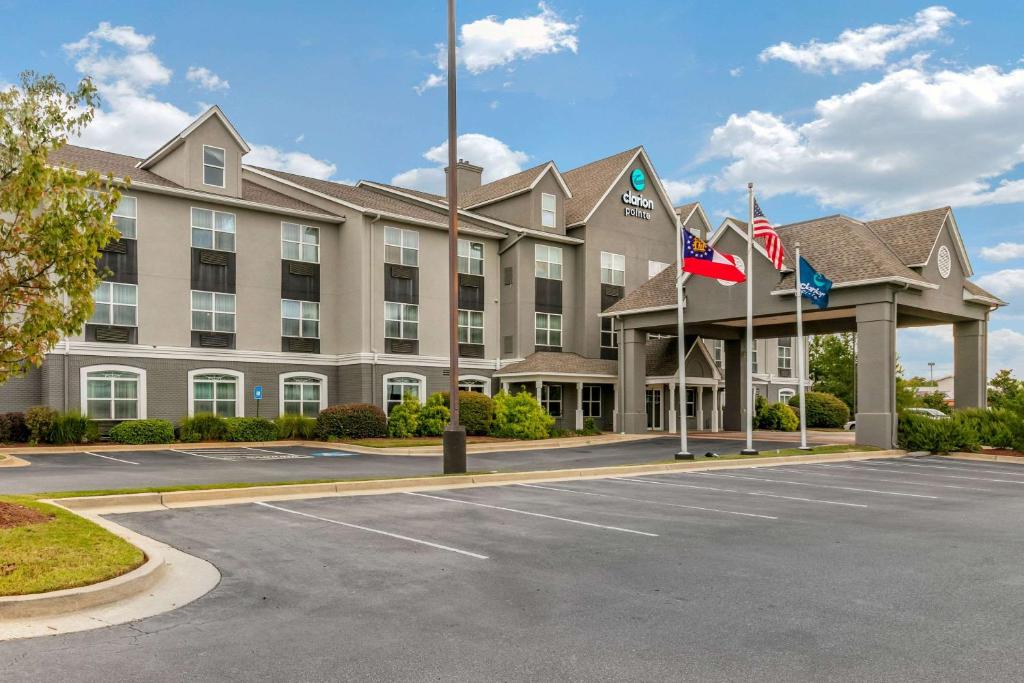 a hotel with flags in front of a parking lot at Clarion Pointe Columbus-Bradley Park in Columbus