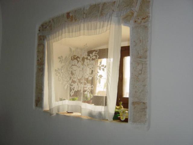 un espejo colgado en una pared con una ventana en Depéndance en Polignano a Mare