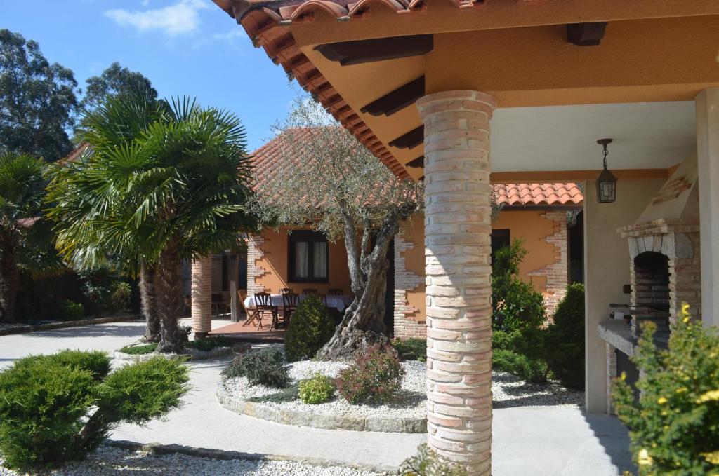 een huis met een palmboom en een stenen pilaar bij Casa da Torre, O Rosal in Rosal