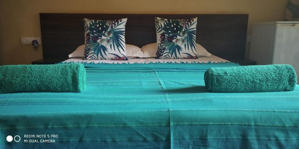 Elle comprend un grand lit avec des draps et des oreillers bleus. dans l'établissement Hotel Bonanza, à Baga