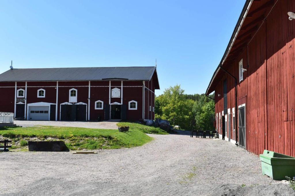 a red barn with a dirt road in front of it at Bränntorps Gård in Kolmården