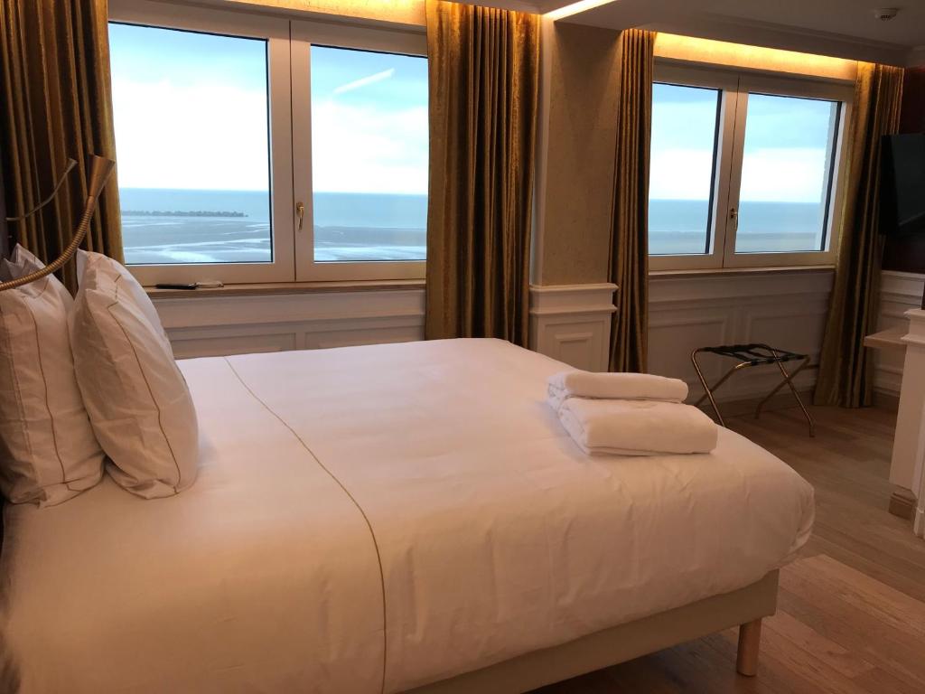 a bedroom with a bed with two towels on it at Hôtel Merveilleux Côté Mer in Dunkerque