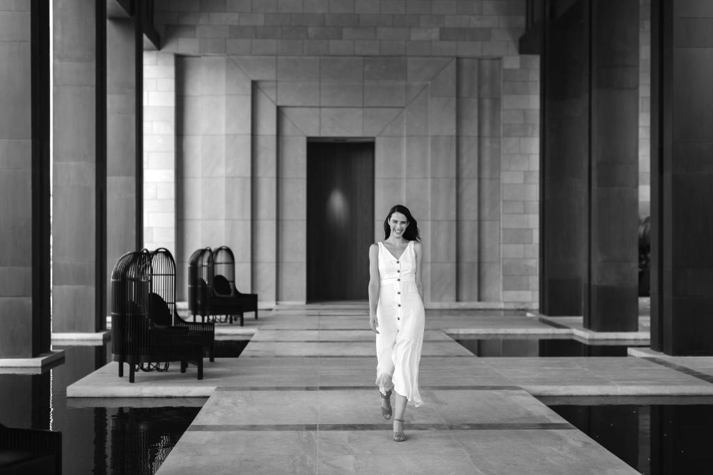 a woman in a white dress walking in a building at Amara - Sea Your Only View™ in Limassol