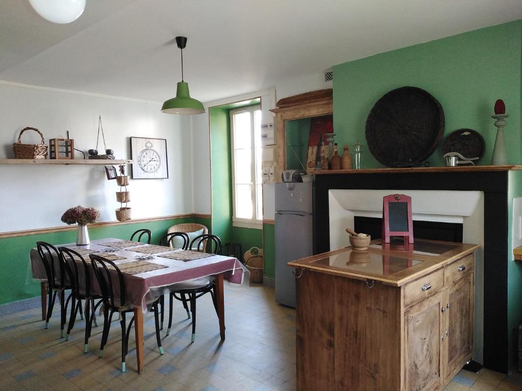 a kitchen and dining room with a table and a fireplace at Meublé de tourisme La Maison d'Orgy in Chevannes