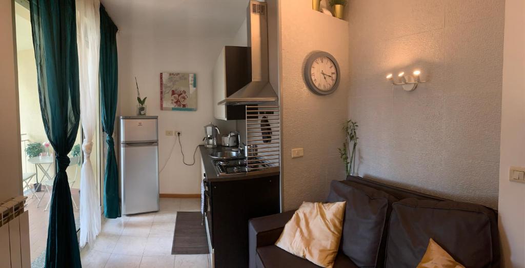 ein Wohnzimmer mit einem Sofa und einer Uhr an der Wand in der Unterkunft Malpensa Home Rent in Gallarate