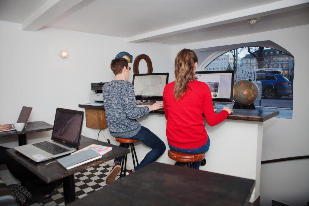 a man and woman sitting at a counter in an office at City Backpackers Hostel in Stockholm