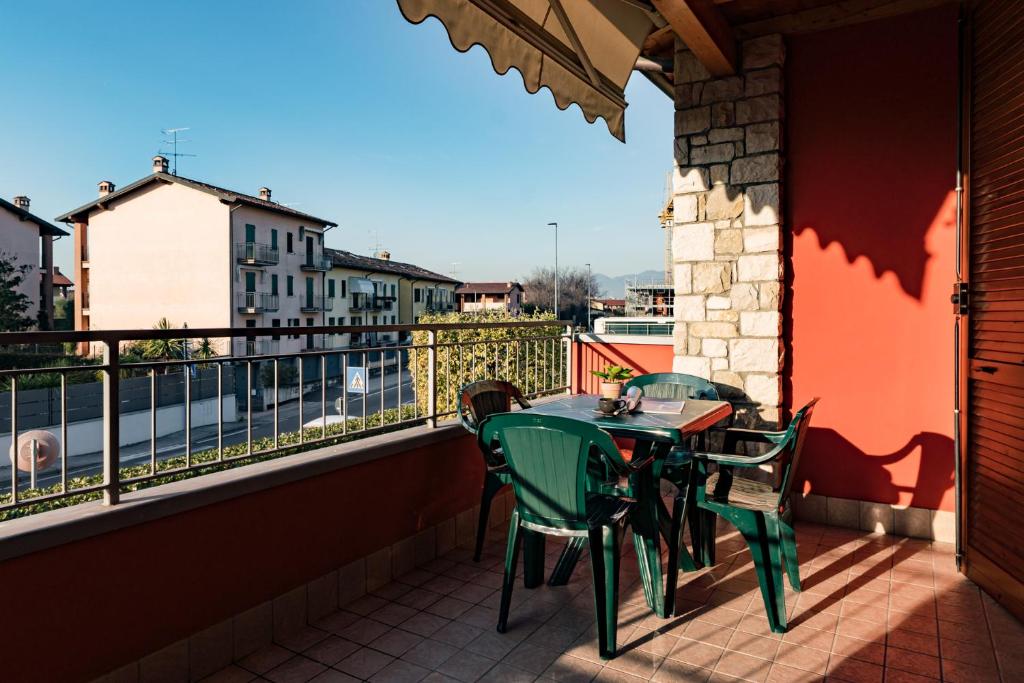 un patio con tavolo e sedie sul balcone. di Gardappartamenti Artisti Pool a Desenzano del Garda