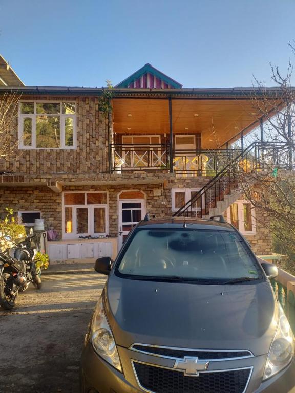 a car parked in front of a house at Shanti Jungle cottage in Mashobra