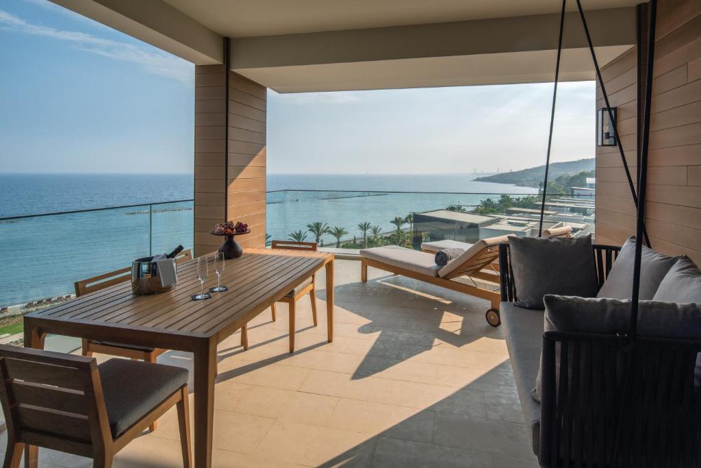 a balcony with a table and chairs and the ocean at Amara - Sea Your Only View™ in Limassol