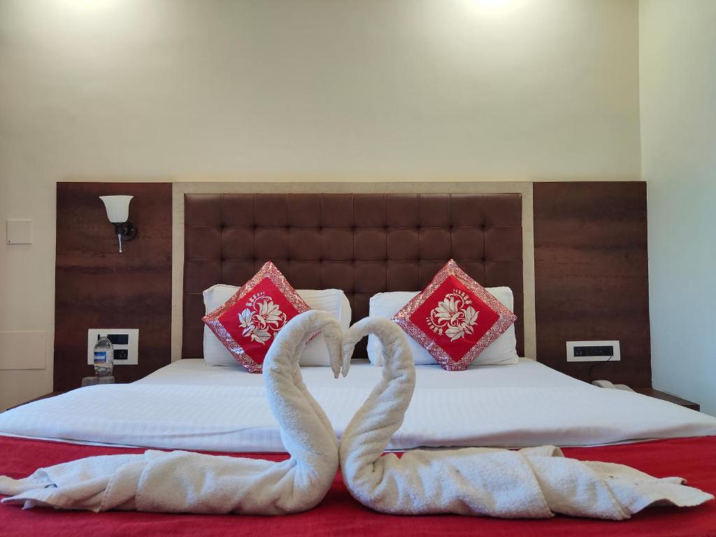 two swans made out of towels on a bed at Hotel Grand Ganesha in Ganpatipule