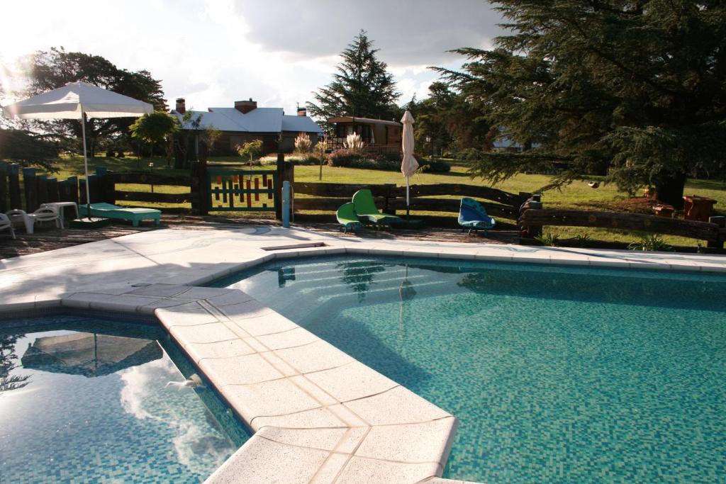 uma piscina com um banco num quintal em Via Pringles Cabañas Boutique em Sierra de la Ventana