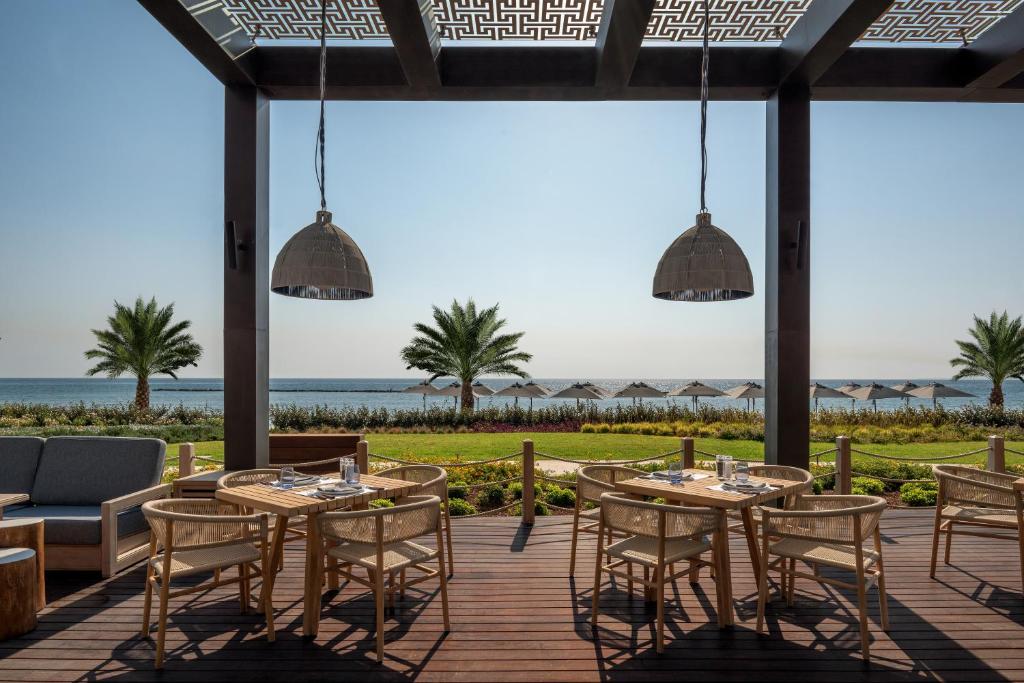 a patio with tables and chairs and the ocean at Amara - Sea Your Only View™ in Limassol