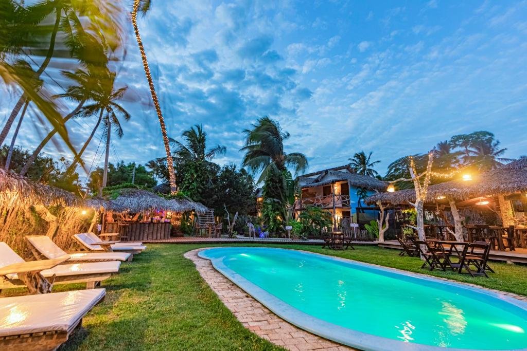 uma piscina com espreguiçadeiras e um resort em Pousada Titas em Barra Grande