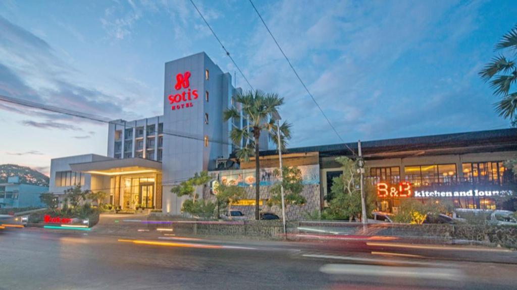 a building with a sign on the side of a street at Sotis Hotel Kupang in Kupang