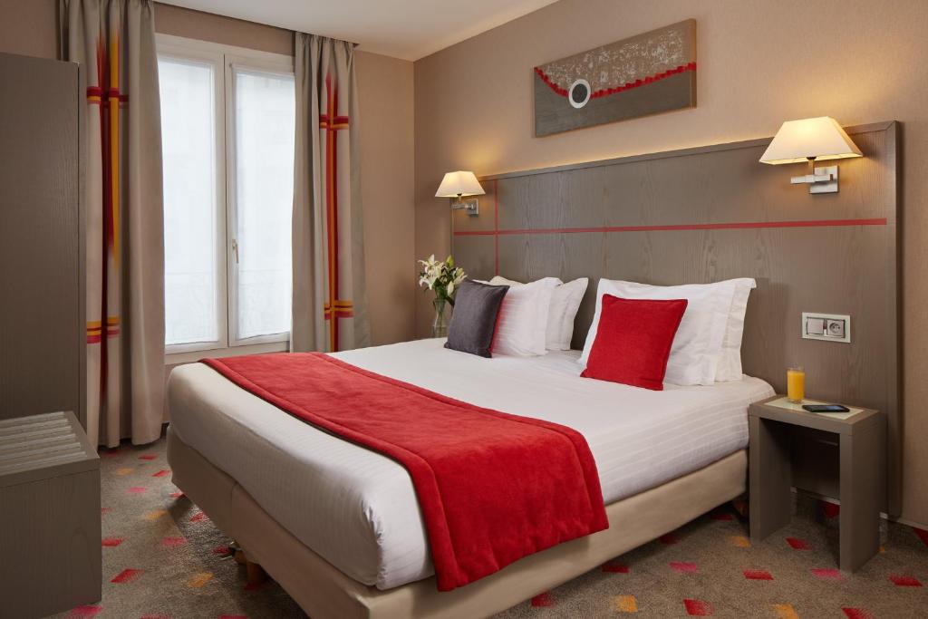 Cette chambre comprend un grand lit avec une couverture rouge. dans l'établissement Alizé Grenelle Tour Eiffel, à Paris