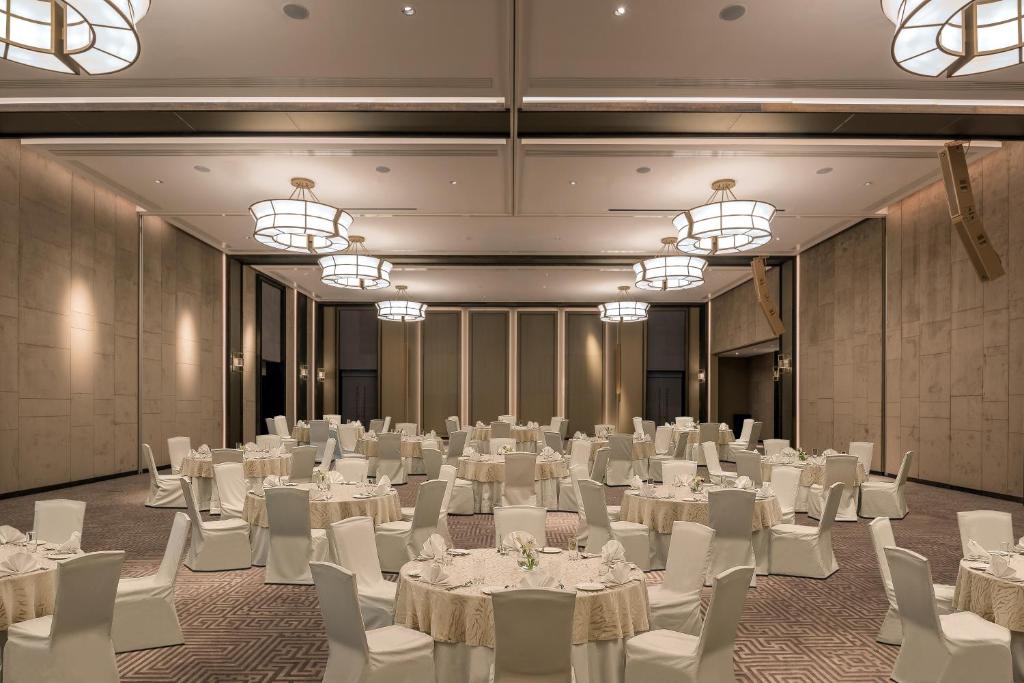 a banquet hall with white tables and chairs and chandeliers at Amara - Sea Your Only View™ in Limassol