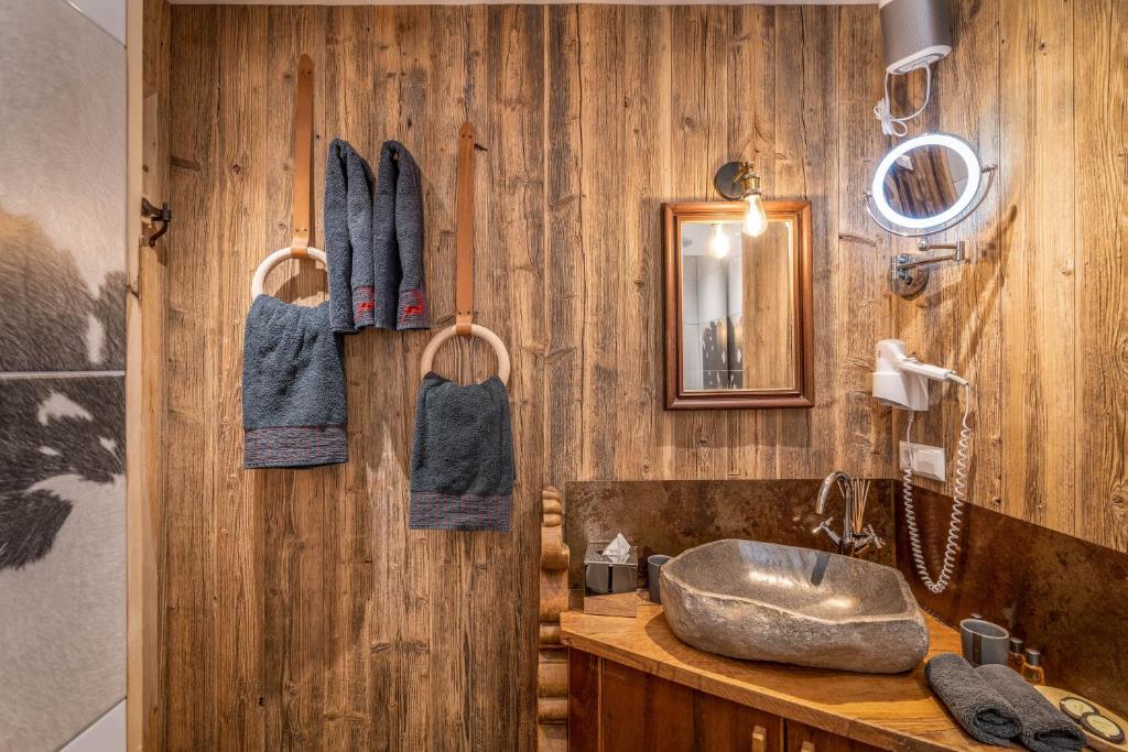 a bathroom with a sink and a wooden wall at Chalet Harmonie in Inzell