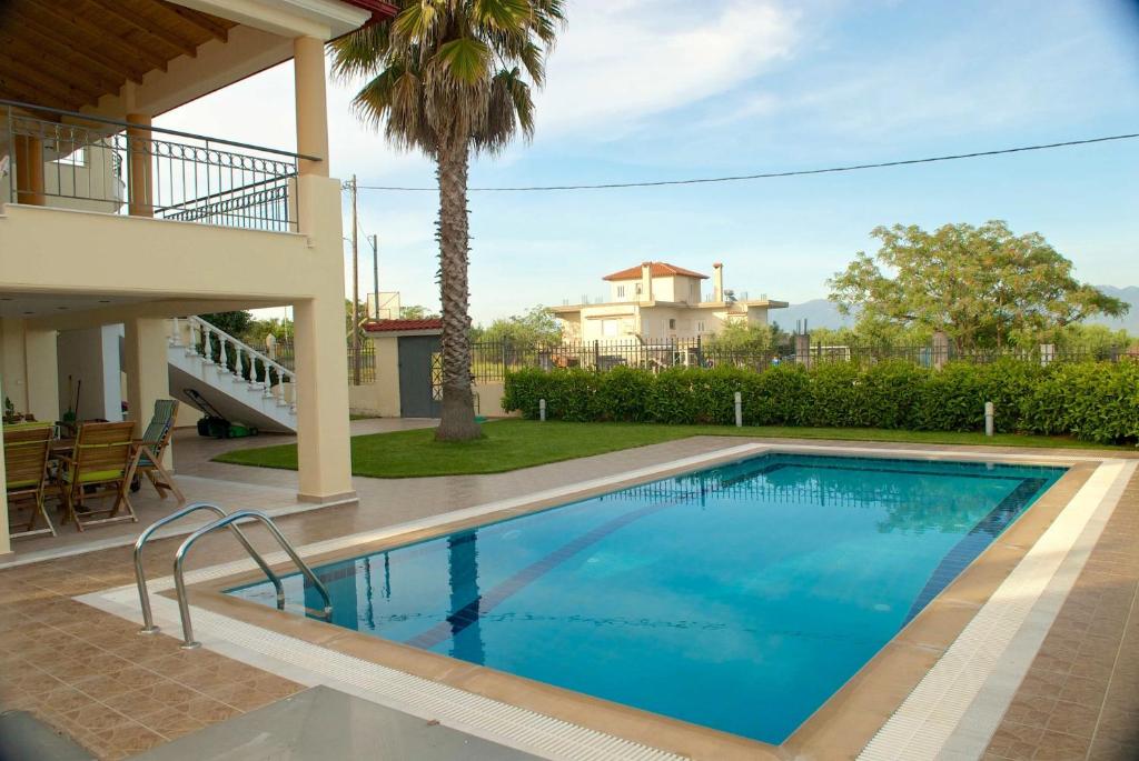 Luxury villa with a swimming pool in Lefkochoara, Messinias في Levkokhóra: مسبح امام بيت فيه نخله