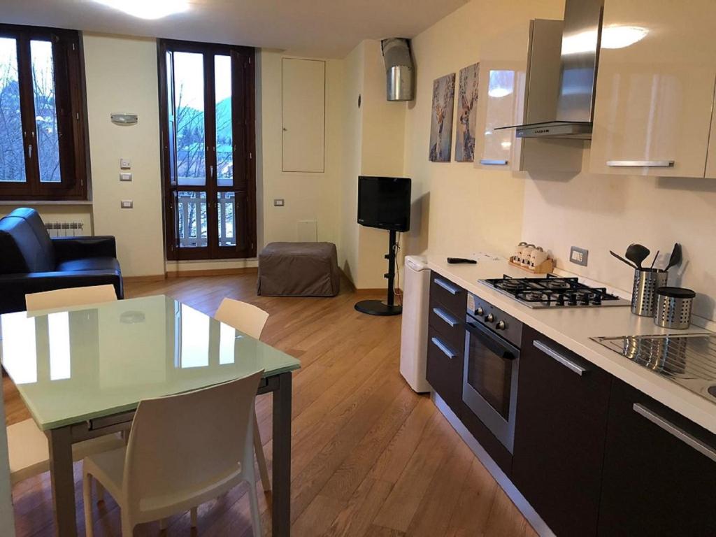 a kitchen and living room with a table and a stove at FORT.Montagna A106 in Rivisondoli