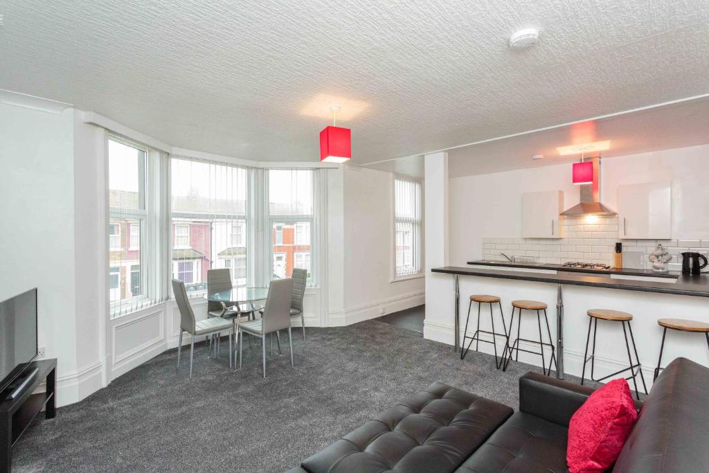 ein Wohnzimmer mit einem Sofa und einer Küche in der Unterkunft Cherry Property - Berry Apartments in Blackpool