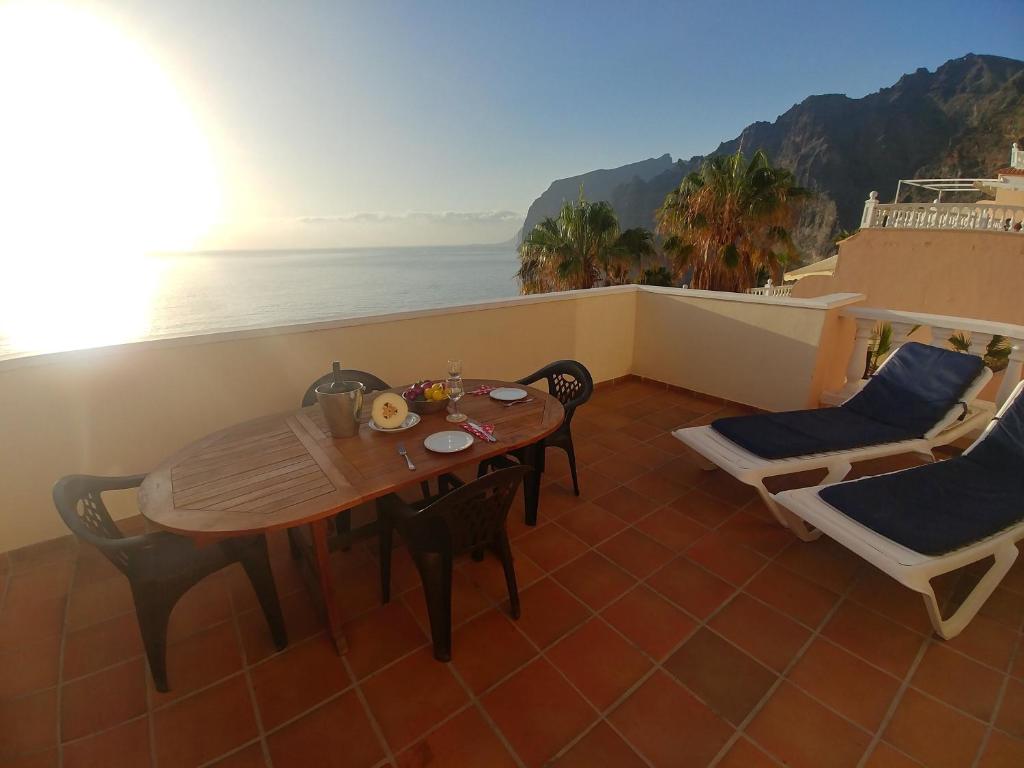 stół i krzesła na balkonie z widokiem na ocean w obiekcie Vivienda Vacacional Los Gigantes w mieście Santiago del Teide