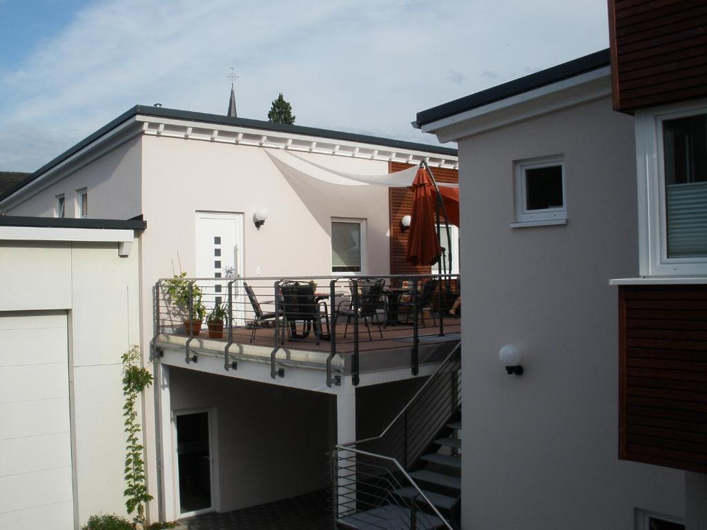 a balcony with a table and chairs on a house at Weingut Markus Busch in Pünderich