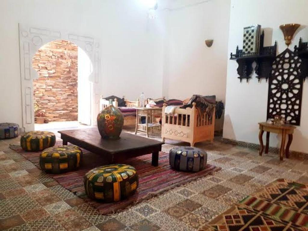 a living room with a table and some ottomans at Arabian Nights Hostel in Cairo